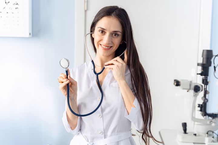 Médecin souriante tenant un stéthoscope dans un cabinet médical